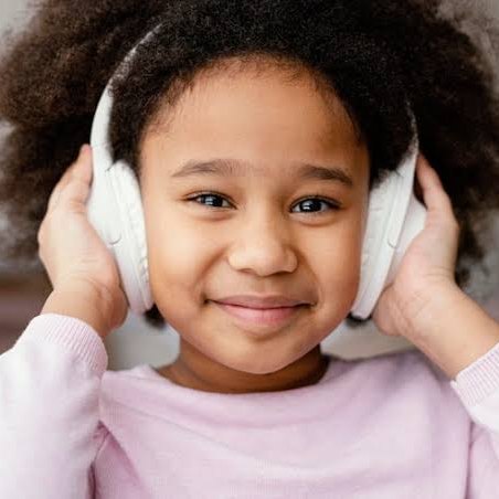 A smiling girl listening with her headphones on